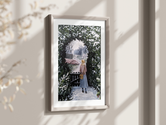 A framed art print featuring a winter scene with a young girl walking through a gate, surrounded by snow-covered evergreens and frost-covered ground, displayed on a wall in a room with natural lighting.