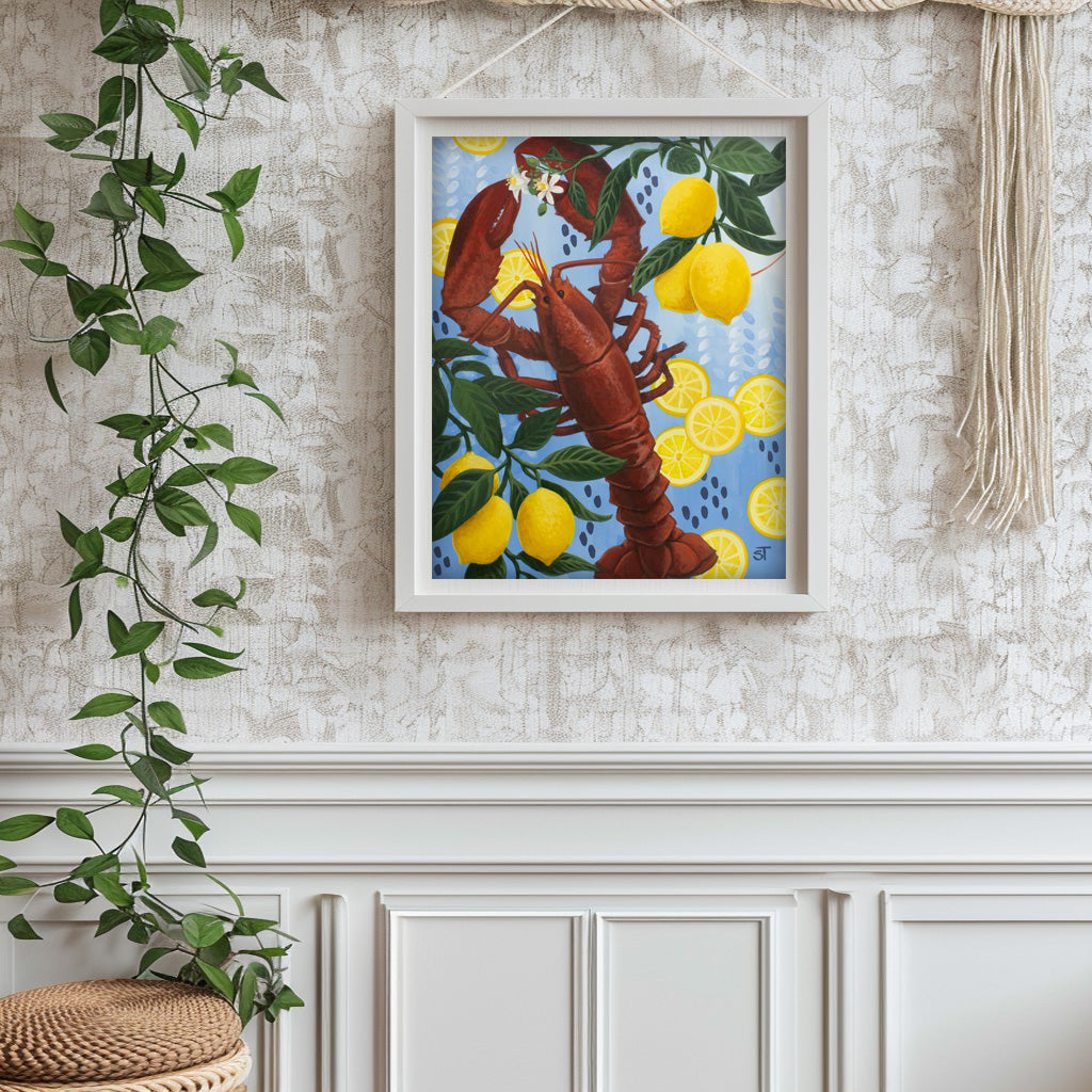 Framed artwork of a lobster and lemons on a textured wall with a plant.