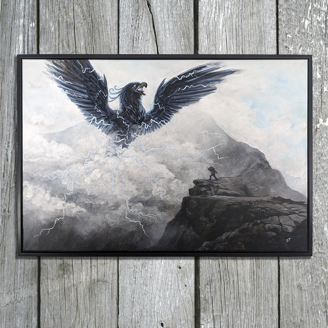 Framed original painting of Pamola, a thunderbird spirit with wings spread and lightning streaking through storm clouds above a rocky mountain ledge, displayed in a black frame on weathered gray wooden boards.