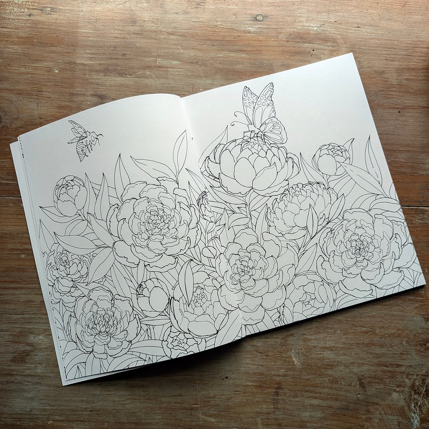 Sample interior coloring book spread featuring detailed floral line art with peonies and leaves.
