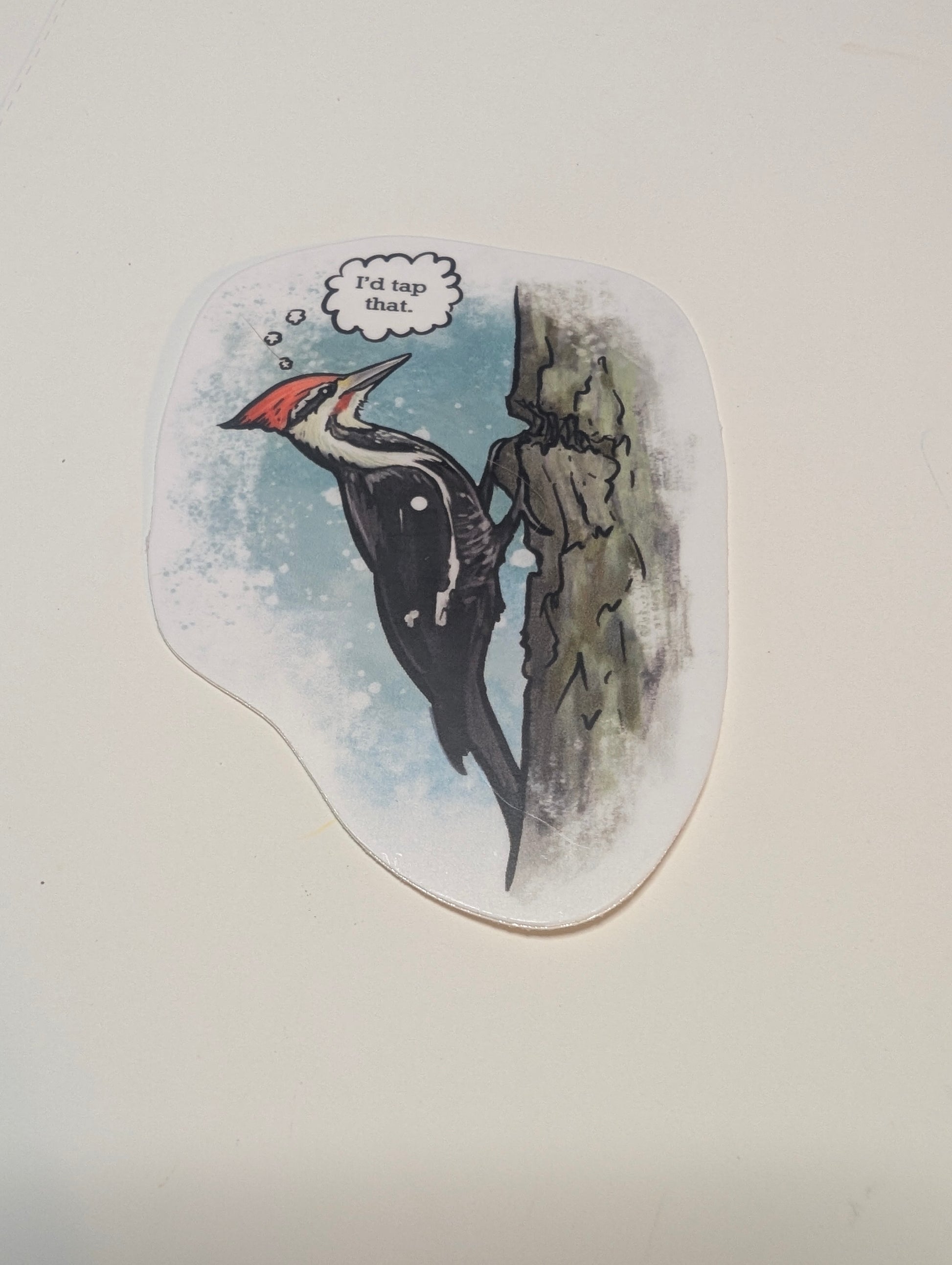 A vinyl decal featuring a cartoon illustration of a woodpecker with a thought bubble saying 'I'd tap that'.