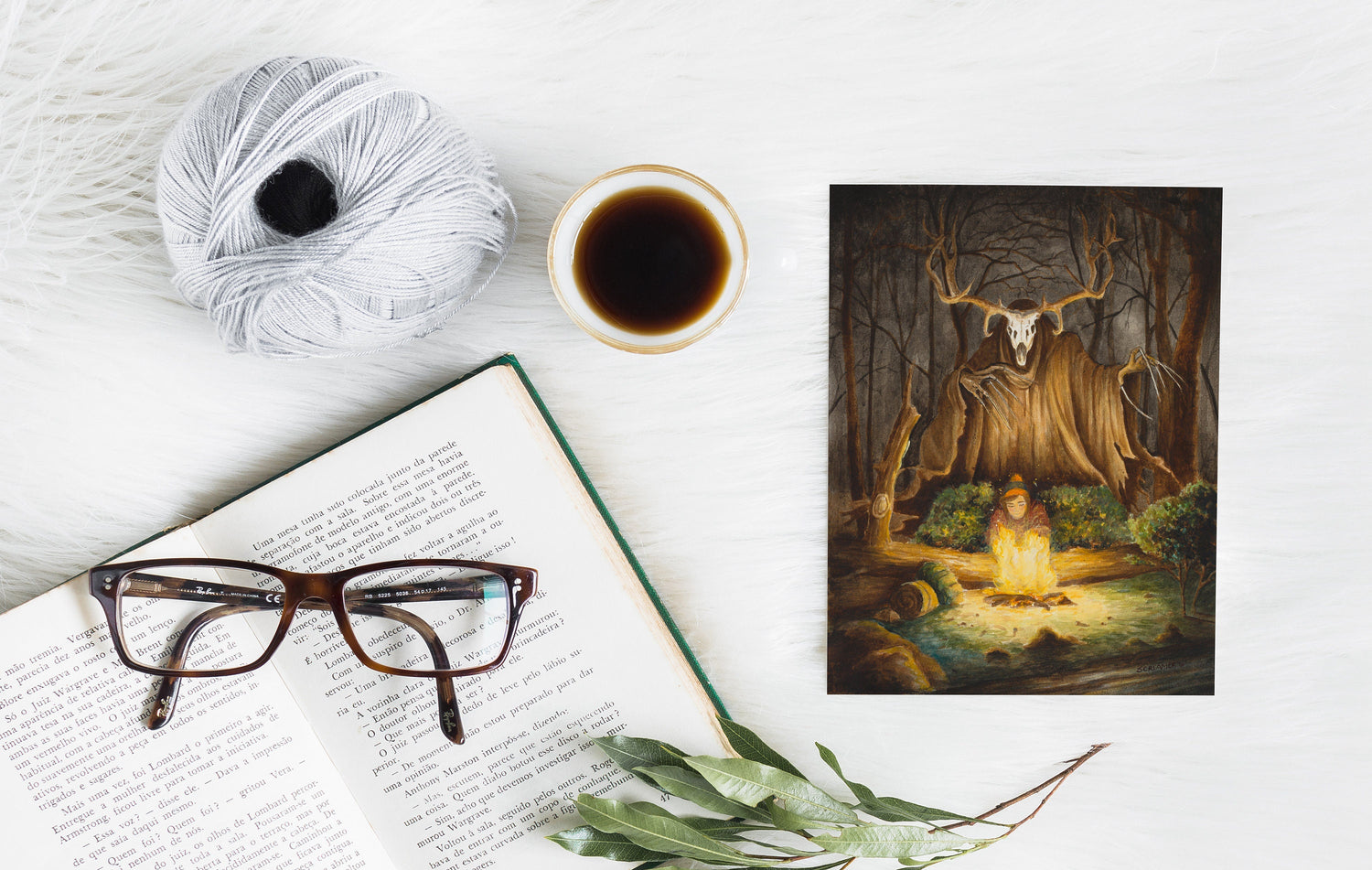 Wendigo with a skull-like deer head towering over a campfire in a dark forest, painted in warm firelight and deep shadows, shown as a greeting card on a white surface.