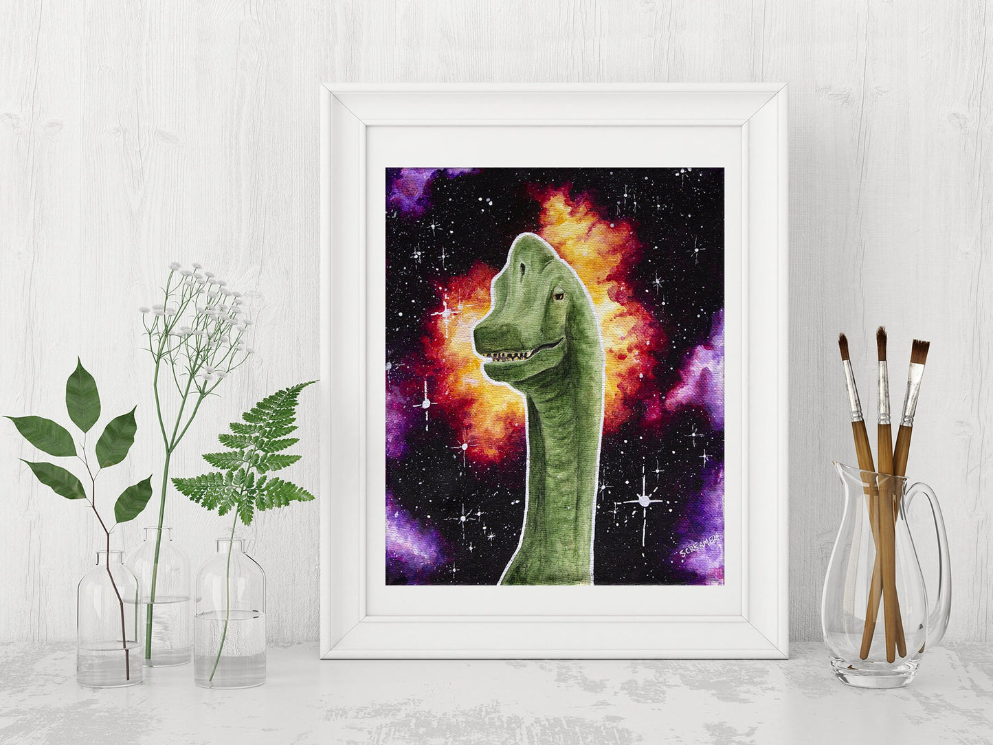 Framed art print featuring a brachiosaurus dinosaur with a space background, displayed on a white shelf with jars of greenery and paintbrushes as decor. 