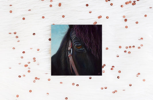 A greeting card with a reproduction of an acrylic painting of a close-up view of a horse's eye, surrounded by decorative sequins.